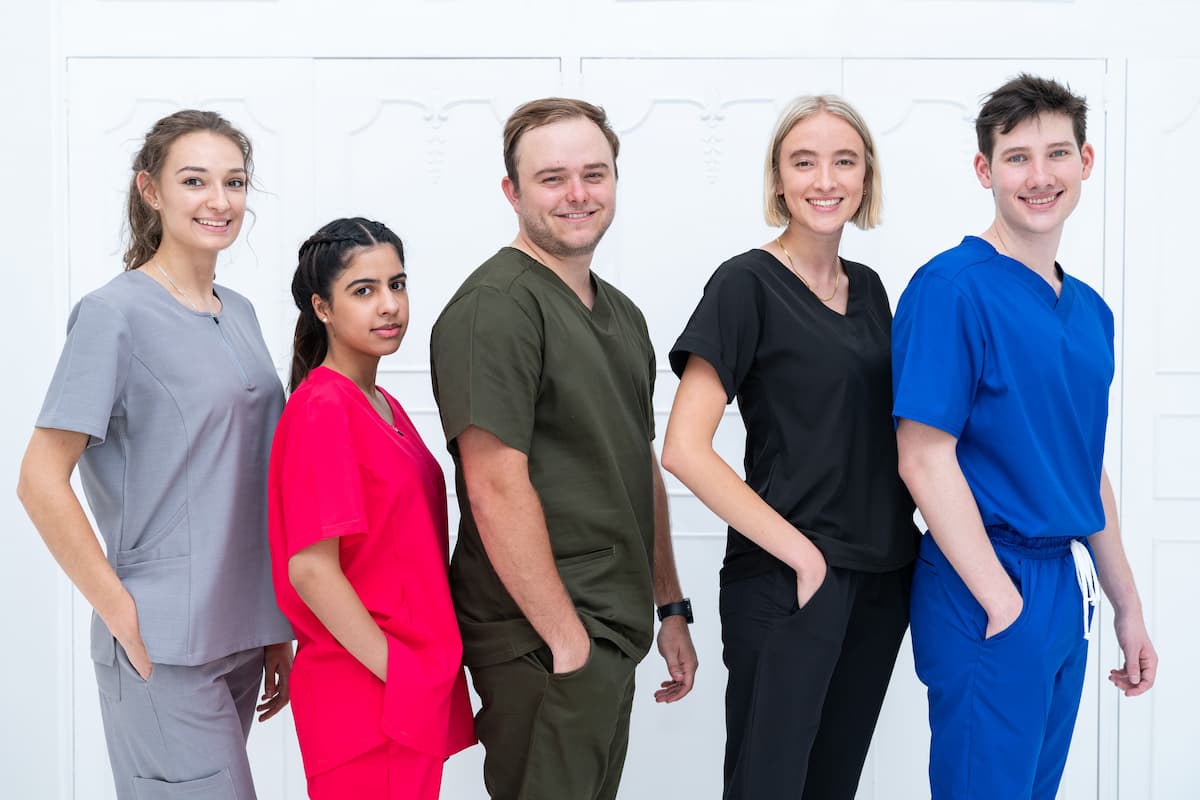 Body Motion Scrubs for Healthcare Professionals Three women’s scrub sets in different sizes, showcasing tailored fit and style.